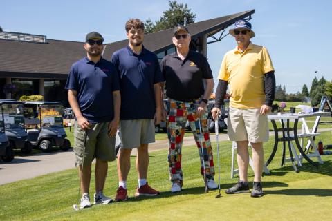 Group photo of two SOBC athletes and two golfers at a golf course