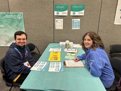 SOBC athlete and volunteer health professional smiling and sitting at a desk